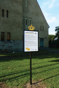 Na zdjęciu widoczna jest tablica z napisem: "Leszczyńskie po królewsku". Jest na niej opisany kościół poewangelicki w Kaszczorze. Opis jest także w języku angielskim.