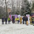 Na zdjęciu widoczni są strażacy, policjanci, przedstawicielki sanepidu oraz wójt.