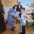 Na zdjęciu widoczna kobieta, która wręcza uczniowi dyplom.