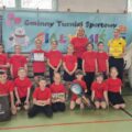Grupowe zdjęcie drużyny z Radomierza. Dzieci pozują z dyplomem i medalami.