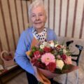 Na fotografii jubilatka pozuje z bukietem kwiatów.