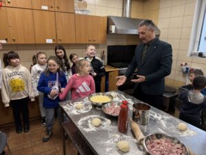 Dzieci oraz wójt w kuchni. Trwają warsztaty pizzy.