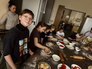 Dzieci przygotowują pizzę.