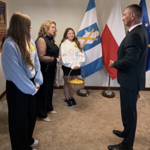 Na zdjęciu widać wójta oraz uczniów i nauczycielkę.