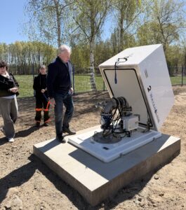 Na fotografii widoczny wykonawca. który pokazuje studnie.