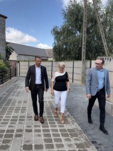Na zdjęciu zastępca wójta, sołtys i radny. Idą wzdłuż jednej z dróg.
